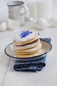 Pancakes with icing sugar and cornflower petals