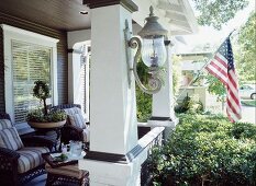 Furnished veranda with stars and stripes flag hanging from column