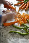 Frauenhände beim Karottenschälen