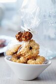 Small bags of biscuits decorated with miniature cake moulds as guest favours