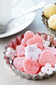 Small cake mould used as dish for sweets & flower-shaped sugar cubes