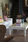 White-painted coffee table and sofa in rustic interior with foot of staircase