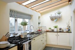 Bright, country-house-style fitted kitchen with glass ceiling