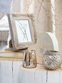 Silver tealight holders and picture frame on whitewashed tree stumps