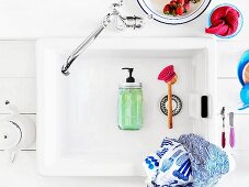 Soap dispenser hand-crafted from preserving jar lying in vintage sink