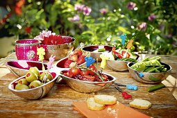 Vegetables and fruit in small bowls on a table outdoors