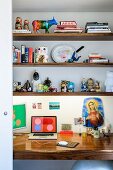 Bizarre mixture of ornaments on desk and floating shelves above