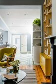 Living room in shades of yellow and green; kitchen in pale shades of blue in background