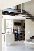 Open kitchen-dining room; steel staircase with wooden tread surfaces in foreground