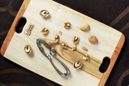Walnut halves with a nutcracker on a wooden board