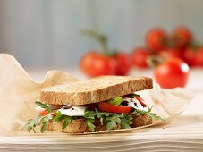 A wholegrain bread sandwich filled with tomatoes and mozzarella