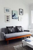 Gallery of photos above grey, retro sofa and white coffee table with chrome legs on long-pile rug