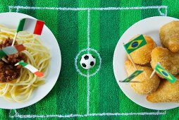 Spaghetti (Italy) and salgadinhos (Brazil) with football-themed decoration