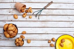 New potatoes in a bucket, in a clay pot and on a plate