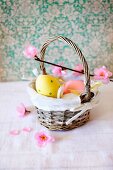 Eggs painted in pastel colours for Easter in a small basket