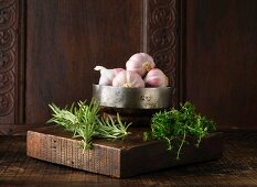 Garlic, rosemary and thyme on rustic wooden board