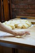 Hände formen Brötchen in der Bäckerei