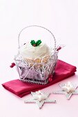 Christmas cupcake in a little silver basket and a star-shaped tealight