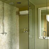 Duschkabine in Grün mit Mosaikfliesenwand und Glastür