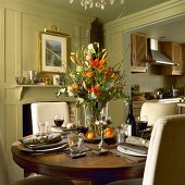 Gedeckter Tisch mit Blumenstrauss und Rotwein in einem Landhaus