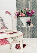 Bouquet of roses in conical vase on small plexiglass table next to chair upholstered in fabric with fifties pattern