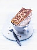 A slice of zebra cake in a coffee cup