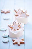 Gingerbread stars garnished with icing in a wooden box and around it