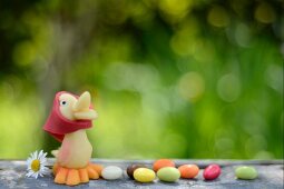 Marzipan chick and jelly beans on a garden table