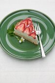 Ein Stück Quarkkuchen mit frischen Erdbeeren