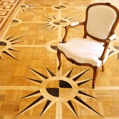 Rokoko Stuhl auf Parkettboden mit Windrosen-Motiv als Intarsie
