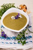 Herb soup with edible flowers