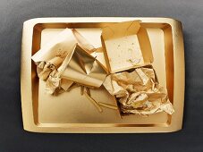 The remains of a fast food meal on a gold-coloured tray