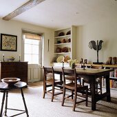 Rustic dining room - wooden dining table and chairs; ceramic bowls on dresser in corner