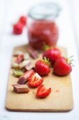 Erdbeeren, Rhabarber und Erdbeer-Rhabarber-Marmelade auf Holzbrett
