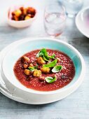 Iced melon gazpacho with tomatoes, croutons, bacon and basil leaves