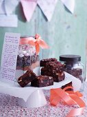 Dark chocolate brownies with a jar of ingredients and a recipe on a doily