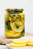 Ansatz für Limonade aus Löwenzahnblüten, Zitronen und Zucker im Glas