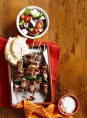 Beef skewers with bacon and courgette, served with a Greek salad