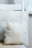 Cushion covers decorated with lace ribbon and crocheted doilies