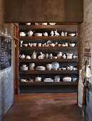 Küchendurchgang und Blick auf Regal mit Geschirr vor Wand in rustikalem Ambiente