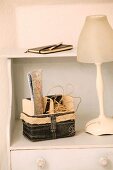 Utensil basket hand-sewn from denim next to table lamp with glass lampshade on chest of drawers