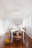 Weisser Tisch und Thonetstühle auf edlem Dielenboden in weißem, minimalistischem Esszimmer