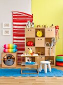 Wooden shelves with storage boxes as organiser in colourful child's bedroom