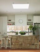 Kücheninsel mit Edelstahl Arbeitsfläche und aus Naturstein Unterbau in weisser Landhausküche