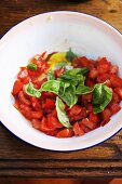 Klein geschnittene Tomaten mit Basilikum in einer Schüssel