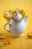 Gingko tea with autumnal gingko leaves in a white teapot