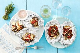 Two dishes grilled in foil: feta with dried tomatoes and eggplant with goat’s cheese