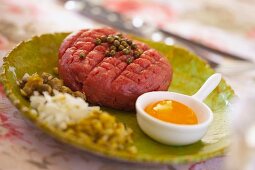 Steak tartare with egg yolk, capers, onions, mushrooms, pickled gherkins and green peppercorns