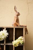 Large display case with cut flowers and hare figurine