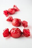Mini meringues (strawberry, rhubarb, passion fruit) in red cellophane